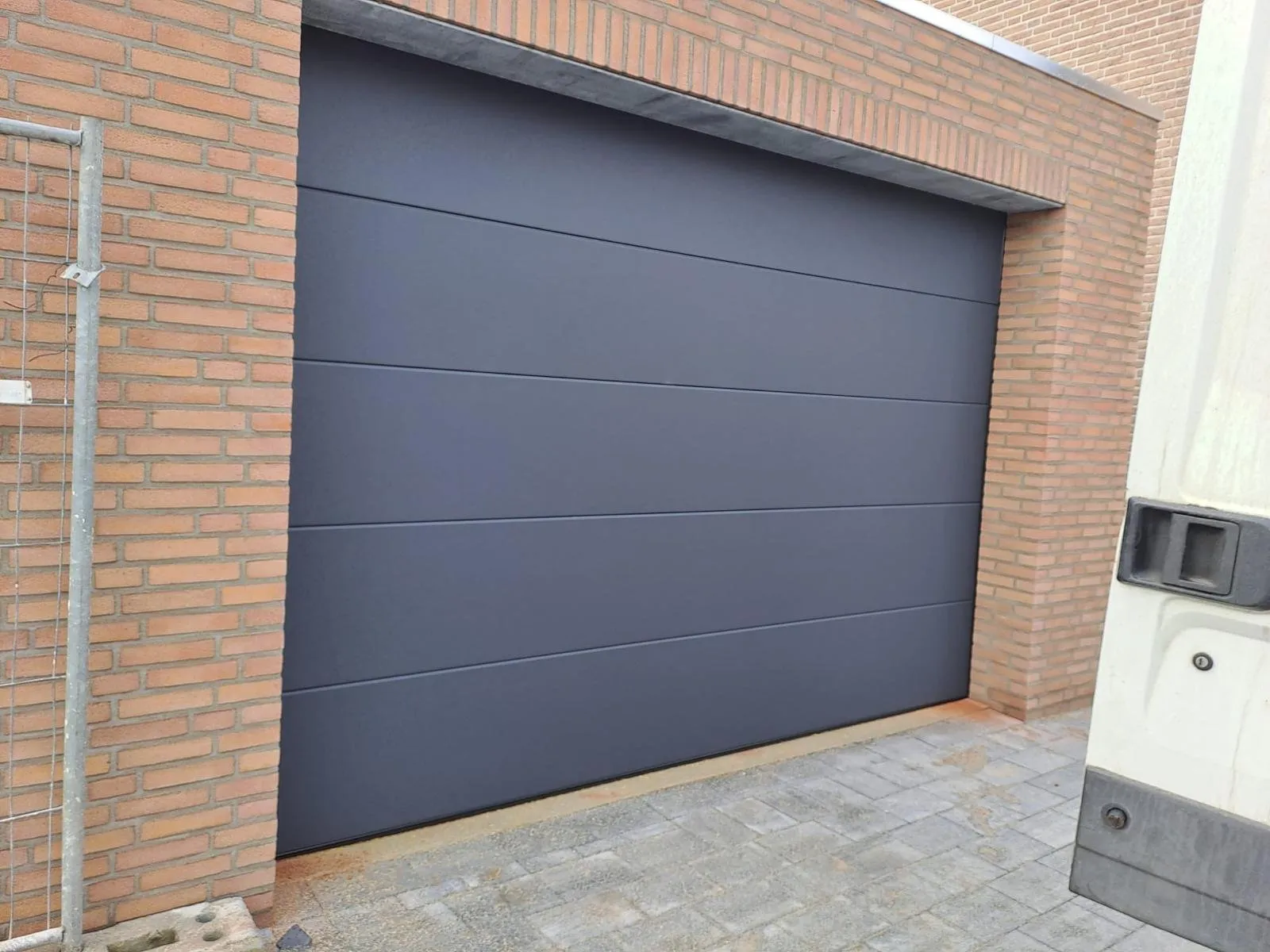 Garage met strak gemetselde gevel en antraciet sectionaaldeur